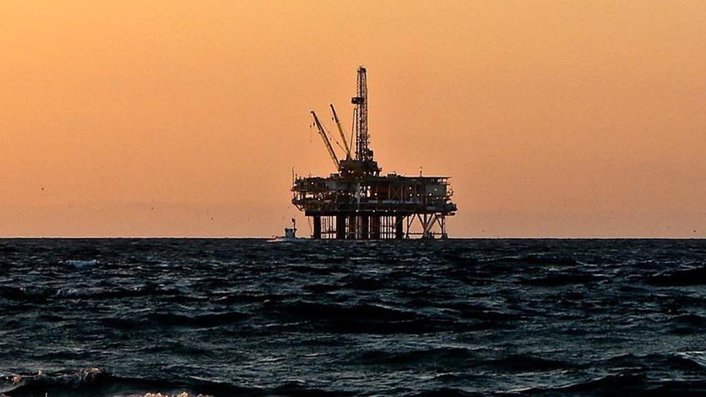 oil rig at sunset surrounded by water