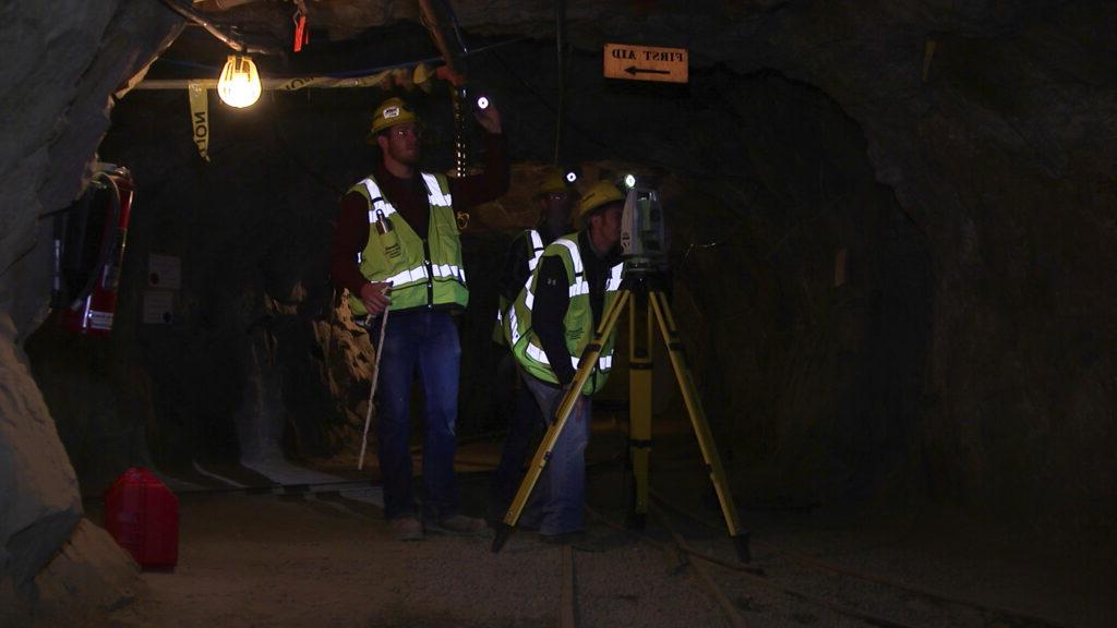 Students working with machinery inside a mine