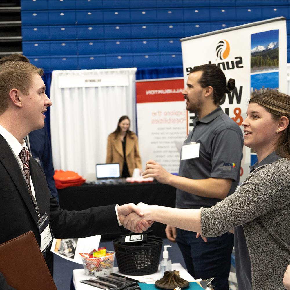 A student and employer shaking hands at career fair