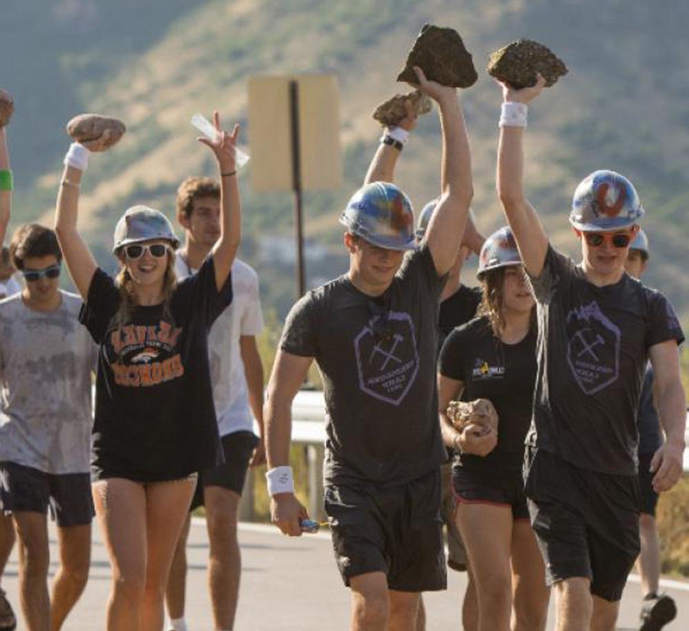 Mines students holding rocks over their heads during the M Climb